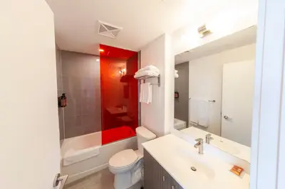 a bathroom with a sink and a toilet and a tub at The Laundry Rooms Station Park Kitchener in Kitchener