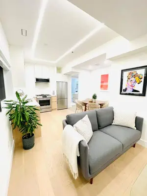 a living room with a couch and a kitchen at Urban 2-bed apartment in the Beaches in Toronto