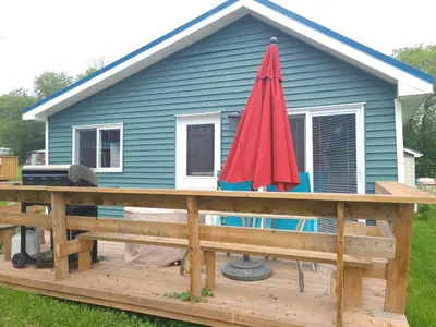 a red umbrella on a deck in front of a house at Stoneburg Cove Cottages in Carrying Place
