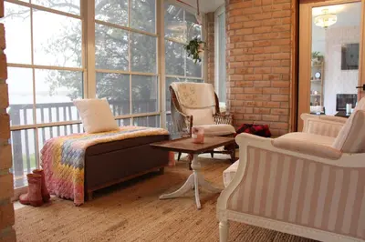 a room with two chairs and a bed and a table at Waterfront Boutique Accommodation in PEC - Suite 3 in Belleville