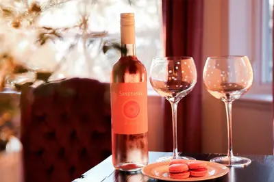 a bottle of wine sitting on a table with two glasses at Waterfront Boutique Accommodation in PEC - Suite 3 in Belleville