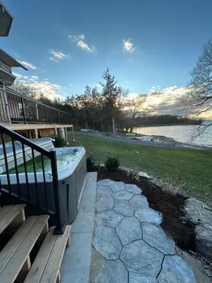 a hot tub sitting on a porch next to a bench at Waterfront Boutique Accommodation in PEC - Suite 3 in Belleville