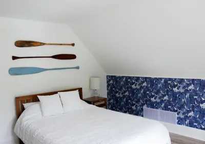a bedroom with a bed and a painting on the wall at Queen Suite with Private Ensuite at Fancie's PEC - Suite 1 in Belleville