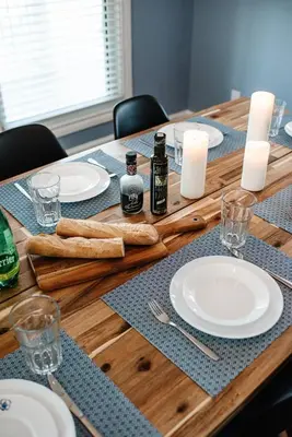 a wooden table with plates and candles on it at Luxurious Lakeview Oasis in the Heart of Hamilton With Large Backyard in Hamilton