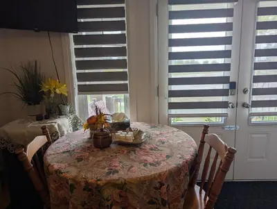 a table in a room with a table with chairs and a window at Honey Dew in Bowmanville
