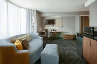 a hotel room with a couch and a desk at Courtyard by Marriott Toronto Northeast/Markham in Markham
