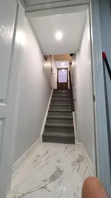 a hallway with a staircase with white marble floors at LUXURY 2-BEDROOMS UNIT WITH WIFI, LDR & PARKING. in Cambridge