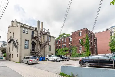 a building with cars parked in a parking lot at Apartment in the James South Neighborhood in Hamilton
