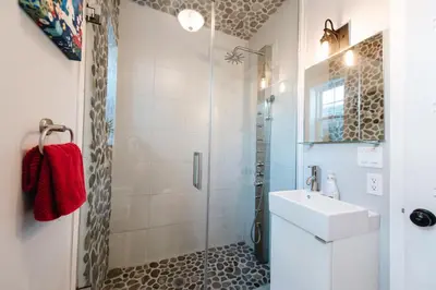 a white bathroom with a sink and a shower at Hamilton's Beach House Stunning Lake Views! Modern Open concept HotTub,firepit, 3BR in Hamilton