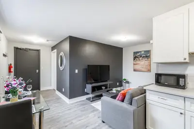 a living room with a couch and a tv at 1BR Basement Condo - James Street in Hamilton