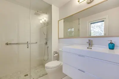 a bathroom with a toilet and a sink and a mirror at Luxurious and Spacious 4BR Home Near Downtown in Burlington
