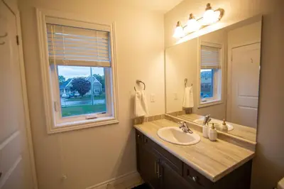a bathroom with a sink and a mirror and a window at Modern & Cozy Retreat Lake Ontario & Wine Country in Grimsby