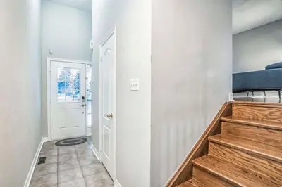 a hallway with a staircase and a white door at Stylish 4BR Home 20 Mins from YYZ in Mississauga