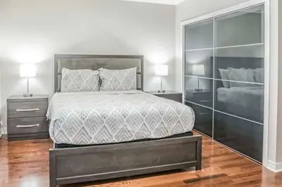 a bedroom with a large bed with two night stands at Stylish 4BR Home 20 Mins from YYZ in Mississauga