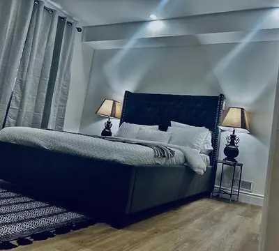a bedroom with a blue bed with two lamps at LaVida Exclusive Guest House, Free Parking (Rm#2) in London