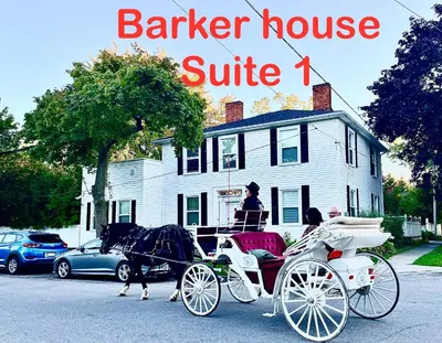a horse drawn carriage in front of a white house at Barker House 1# Suite-heart of oldtown in Niagara on the Lake