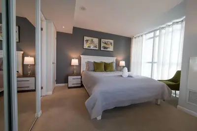 a bedroom with a large bed and two lamps at Downtown Toronto Condo Parking Sleeps 4 Balcony Walk to Lake in Toronto