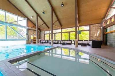 a large swimming pool in a large room with windows at Horseshoe Valley Suites - The Maple in Shanty Bay