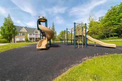a playground with two slides in a park at Horseshoe Valley Suites - The Maple in Shanty Bay