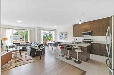 a kitchen and living room with a couch and a table at Beatrice Beach House in Wasaga Beach