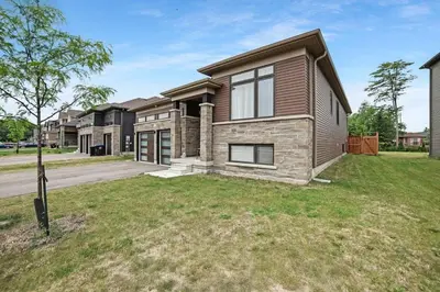 a house on a street with a yard at Beatrice Beach House in Wasaga Beach