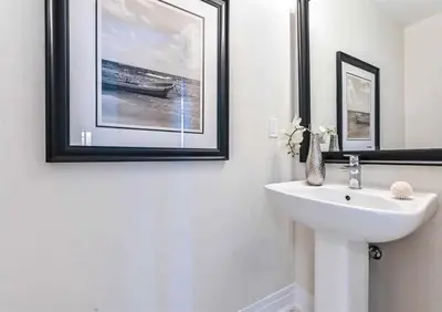 a bathroom with a sink and a picture of a boat at Luxe Toronto Townhome, Rooftop Terrace, Parking in Toronto