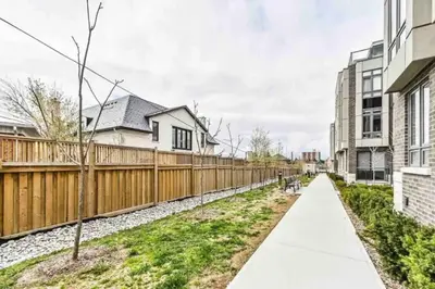 a fence and a sidewalk next to some houses at Luxe Toronto Townhome, Rooftop Terrace, Parking in Toronto