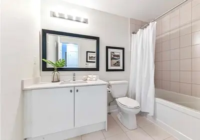 a white bathroom with a toilet and a sink at Luxe Toronto Townhome, Rooftop Terrace, Parking in Toronto