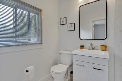 a bathroom with a toilet and a sink and a mirror at Dorado at The Kabins by The Falls in Fenelon Falls