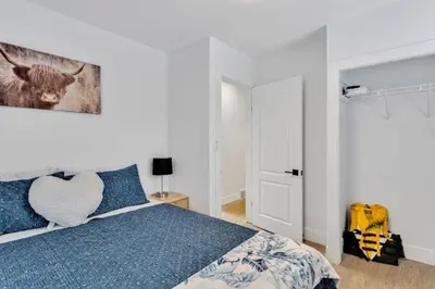 a bedroom with a bed with blue pillows and a painting at Dorado at The Kabins by The Falls in Fenelon Falls