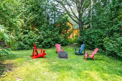 a group of colorful chairs sitting in the grass at Dorado at The Kabins by The Falls in Fenelon Falls