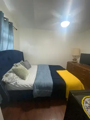 a bedroom with a bed with a yellow and blue blanket at Spruce Lodge in London