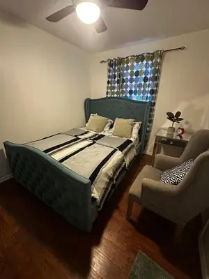 a bedroom with a blue bed and a chair at Spruce Lodge in London