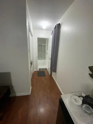 a room with a hallway with a table and a bathroom at Spruce Lodge in London