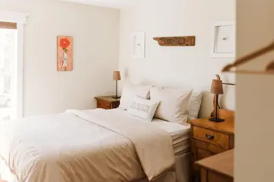 a white bedroom with a white bed and a window at County Escape on Corey in Bloomfield