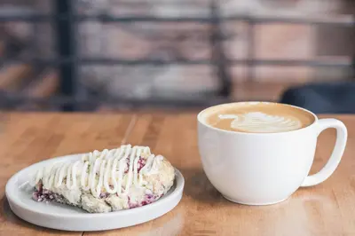 a plate with a doughnut and a cup of coffee at Somewhere Inn Collingwood in Collingwood