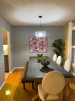 a dining room with a table with chairs and a painting at Bright & Cozy 4BR Home for Your Family Stay With Optional Pool Access in Mississauga