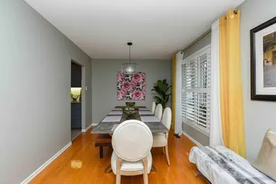 a dining room with a table and white chairs at Bright & Cozy 4BR Home for Your Family Stay With Optional Pool Access in Mississauga
