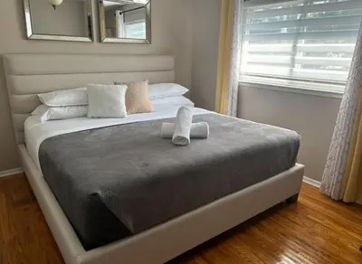 a bed with two towels on it in a bedroom at Bright & Cozy 4BR Home for Your Family Stay With Optional Pool Access in Mississauga