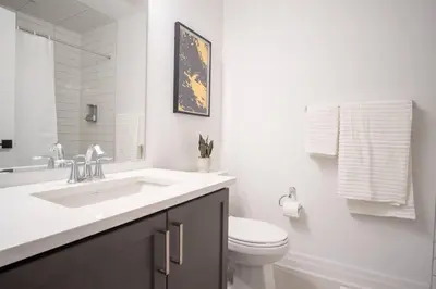 a white bathroom with a sink and a toilet at Modern 4-Bed Townhome with Cinema & Roof Terrace in Oakville