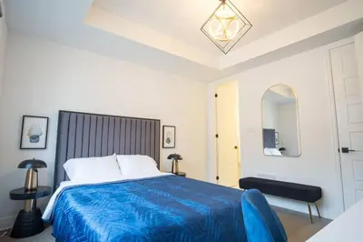 a bedroom with a blue bed with a blue blanket at Modern 4-Bed Townhome with Cinema & Roof Terrace in Oakville