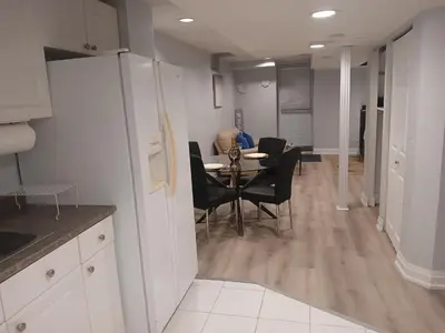 a kitchen and dining room with a table and chairs at Furnished calm basement studio apartment in Mississauga