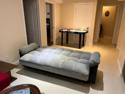 a couch in a living room with a table at 2 bedroom basement with parking in Richmond Hill