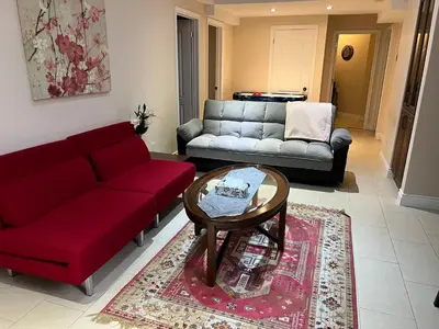 a living room with a red couch and a coffee table at 2 bedroom basement with parking in Richmond Hill
