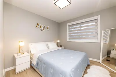 a bedroom with a white bed and a window at Matilda’s Luxury House in Mississauga