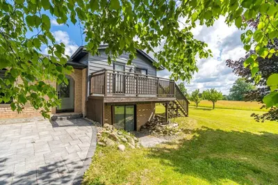 a house with a deck and a lawn at Serene 4BR house with Hot tub, Lake, Billiards and BBQ in Georgina