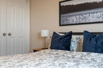 a bedroom with a bed with blue pillows at 6min To Niagara Falls - 4 Free Parking - Foosball in Niagara Falls