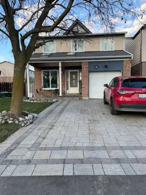 a red car parked in front of a house at Comfortable Stay In Beautiful Home in Milton