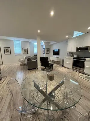 a glass table and chairs in a living room at Luxury Executive Studio in Oakville