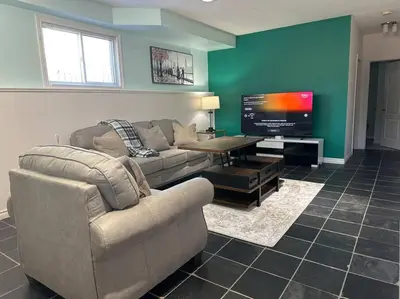 a living room with a couch and a flat screen tv at Luxury Spacious 5-Bedroom Home in London